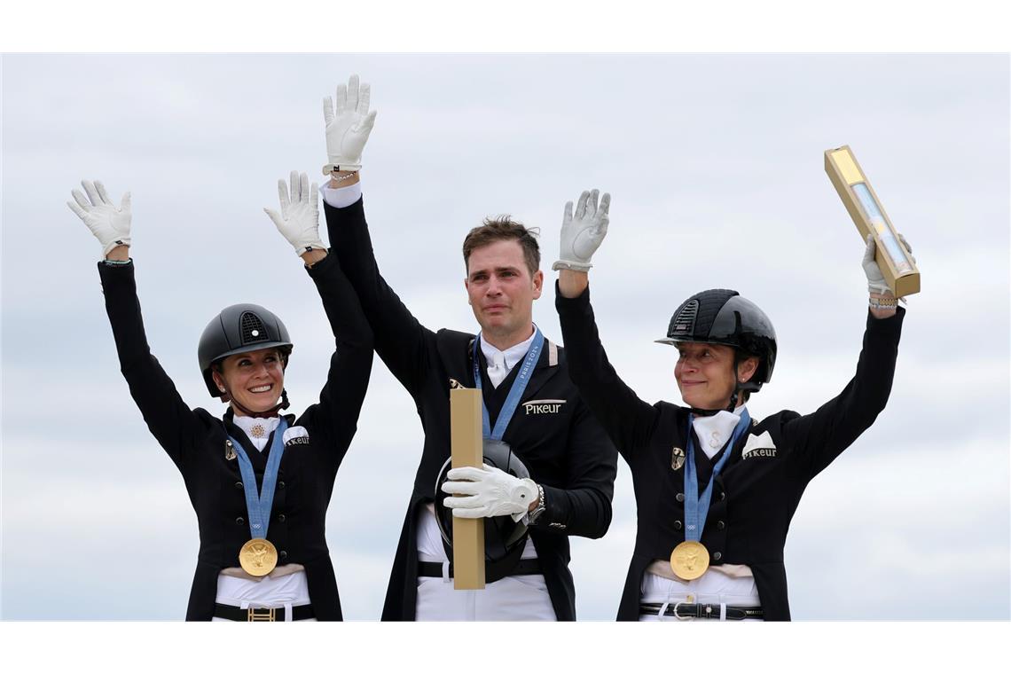 Triumph in Versailles: die deutsche Dressur-Equipe Jessica von Bredow-Werndl (l-r), Frederic Wandres und Isabell Werth jubelt über Gold bei den Olympischen Spielen.