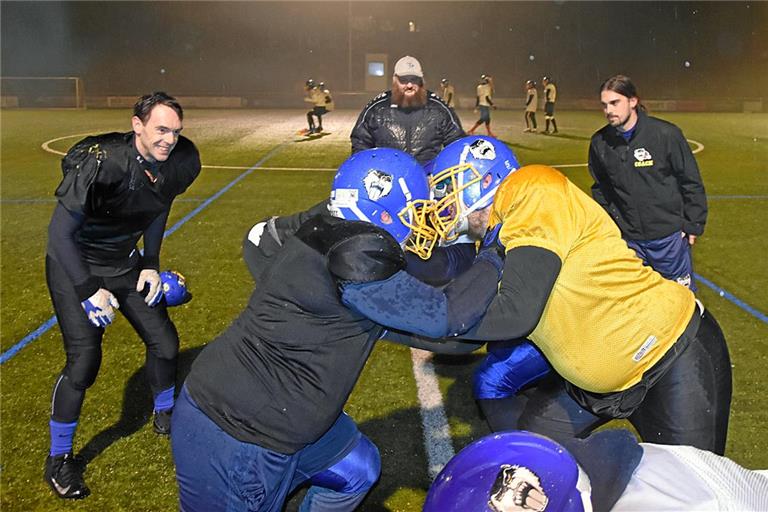 Trotz des widrigen Wetters zeigen die Footballer der Backnang Wolverines im Training vollen Einsatz. Das gefällt Defensive Coordinator Martin Häuser, Offensive Line Coach Oliver Jauß und Offensive Coordinator Jan Kneiser (hinten von links). Foto: Tobias Sellmaier