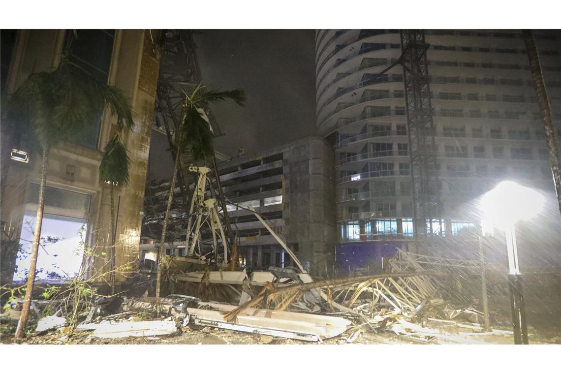 Trümmerteile bedecken den Boden in der Nähe eines Krans in St. Petersburg (Florida), der auf ein Gebäude  gestürzt ist, als die starken Winde des Hurrikans „Milton“ auf Land trafen.