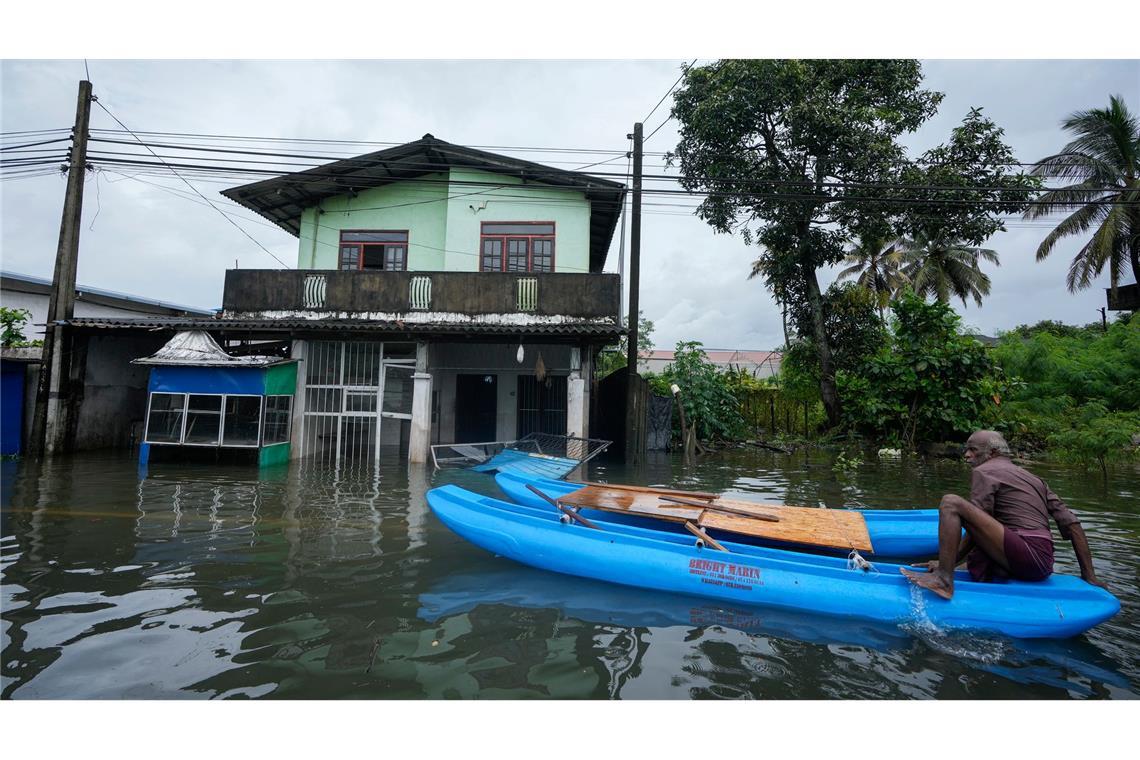 Überschwemmungen in Sri Lanka: Ein Mann ist mit seinem Boot in einem überfluteten Gebiet unterwegs.