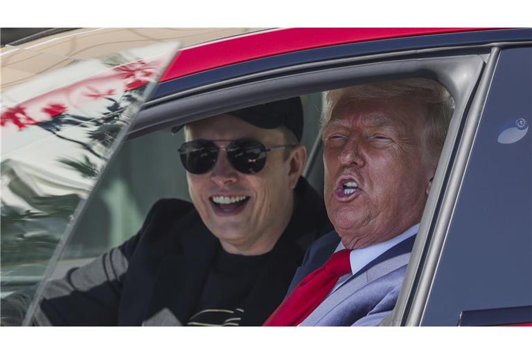 US-Präsident Donald Trump (r) und Tesla-CEO Elon Musk sprechen zu Reportern während Sie in einem roten Tesla Model S Fahrzeug auf dem Südrasen des Weißen Hauses sitzen.