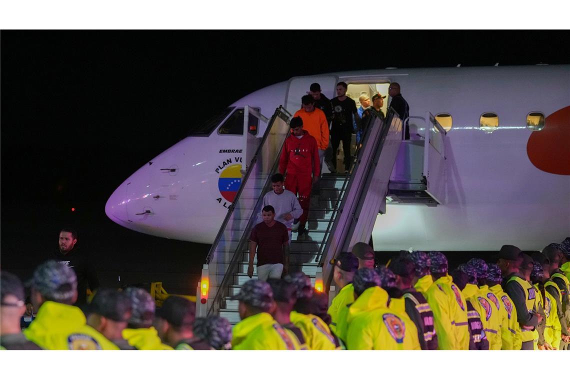 Venezolanische Migranten, die aus den USA abgeschoben wurden, steigen am Flughafen in Maiquetia aus dem Flugzeug.