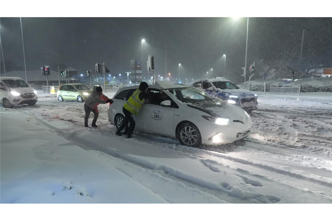 Viel Schnee in Großbritannien: Menschen helfen in Leeds dabei, im Schnee steckengebliebene Autos wegzuschieben.