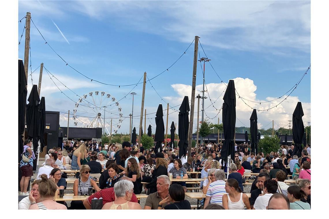 Viele Fans sitzen in der Außengastronomie in der Adele World. Ein Hauch von Oktoberfest in der Adele World vor dem Konzert des Superstars.