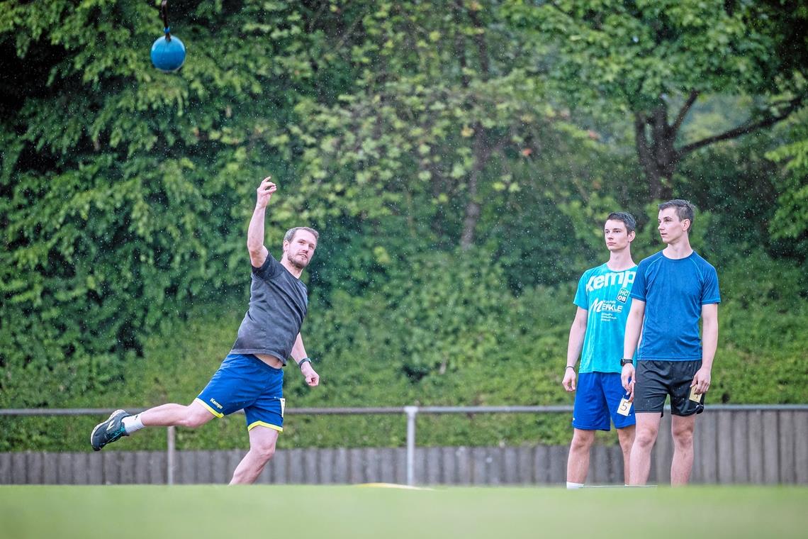 Von zwei Teamkollegen beobachtet, pfeffert HCOB-Handballer Björn Fuggmann den Schleuderball auf den Rasen. Foto: Alexander Becher