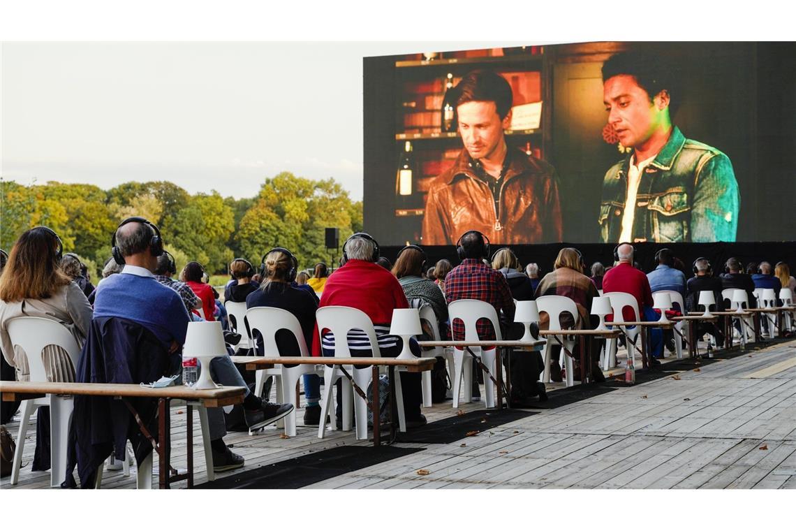 Zuschauer verfolgen beim Festival des deutschen Films auf der Parkinsel auf einer großen LED-Videoleinwand einen Kinofilm.