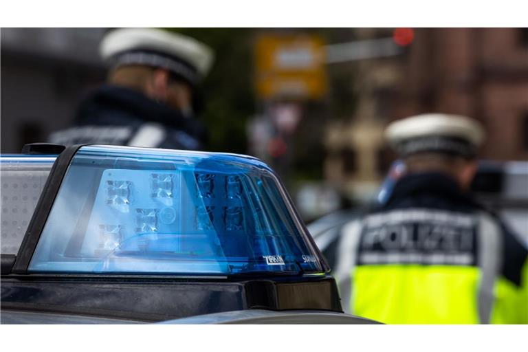 Zwei Polizeibeamte stehen zwischen zwei Einsatzfahrzeugen der Polizei. In Freiburg hat der Leiter einer Kita Morddrohungen erhalten (Symbolfoto).